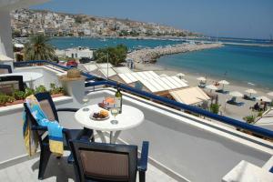 einen Tisch und Stühle auf einem Balkon mit Blick auf den Strand in der Unterkunft Portobelis Apartments in Sitia