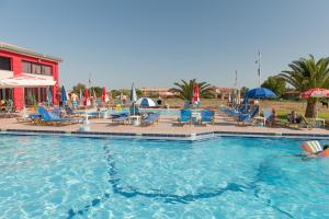 a pool with chairs and umbrellas in a resort at Dina Studios in Kalamaki