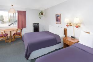 Una cama o camas en una habitación de Redwood Inn