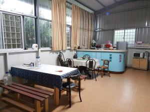 a kitchen with a table and chairs in a room at Ganoun Homestay in Meinong