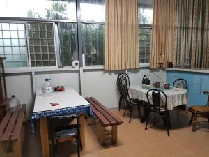 a dining room with a table and chairs and windows at Ganoun Homestay in Meinong