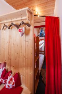 a bedroom with a bunk bed and a red curtain at Chalet Tyrol in Fügen