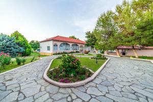 a cobblestone street in front of a building at Sintrivanis Resort Beach in Paralía Skotínis