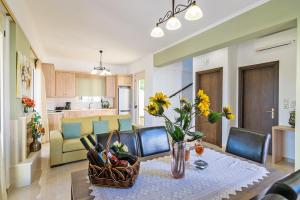 a living room with a table with a basket of flowers at Aphrodite in Adelianos Kampos