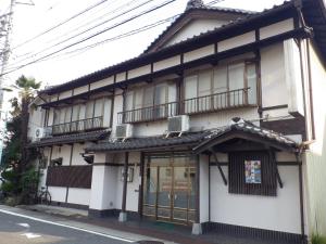 a building with two balconies on a street at Uokagi Ryokan in Nagoya