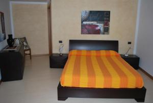 カヴァイオーン・ヴェロネーゼにあるAppartpaolaのベッドルーム1室(オレンジと黄色のストライプの毛布付きのベッド1台付)