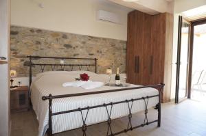 a bedroom with a bed with a stone wall at Villa Giota in Potamiá