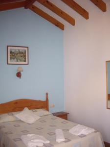 a bedroom with a bed with two towels on it at Hostal Mini Golf in Los Caños de Meca