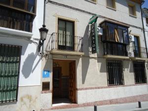 Un edificio con un cartel al costado. en Hostal Los Claveles, en Baena