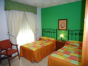 Postel nebo postele na pokoji v ubytování Hostal Los Claveles