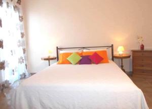a bedroom with a white bed with colorful pillows at Porto Katsiki Blu in Athani
