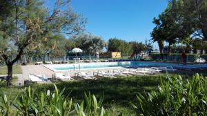a swimming pool with lounge chairs in a park at Villaggio Diomedea in Campomarino