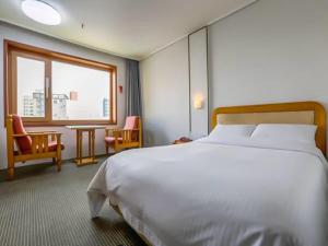 Postel nebo postele na pokoji v ubytování Busan Tourist Hotel