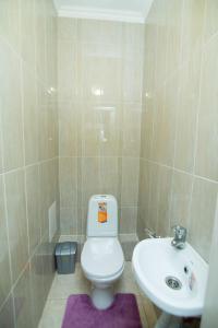 La salle de bains est pourvue de toilettes blanches et d'un lavabo. dans l'établissement Apartments on 7/1 Sarayshyq, à Astana