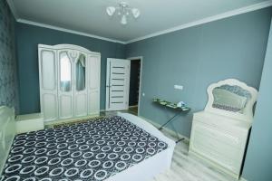 - une chambre bleue avec un lit et un miroir dans l'établissement Apartments on 7/1 Sarayshyq, à Astana