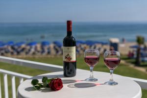 een fles wijn en twee glazen op een tafel bij Happy Days Beach Hotel in Georgioupolis