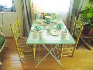 a table with bowls and dishes on it at Chambre en ville dans un esprit campagne in Troyes