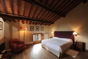 a hotel room with a bed and a chair at Borgo Il Melone in Cortona