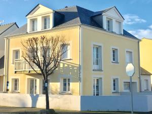 a yellow house with a tree in front of it at Sweet Apartment in Saint Malo