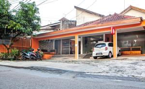 a white car parked in front of a building at RedDoorz Syariah near BTC Fashion Mall in Bandung