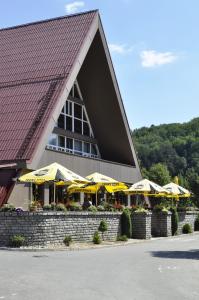 a restaurant with yellow umbrellas in front of a building at Apartman 4 Vsemina Valassko in Všemina