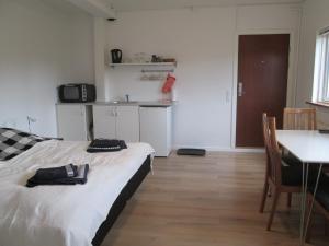 a hotel room with a bed, table and a television at Hos Tina in Roskilde