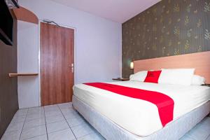 Postel nebo postele na pokoji v ubytování RedDoorz Syariah near BTC Fashion Mall + 15 fotografií