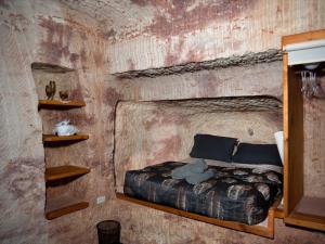 a bedroom with a bed in a room with a brick wall at Ali's Underground Studio in Coober Pedy