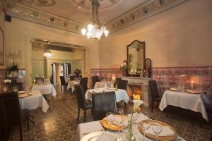 a restaurant with white tables and chairs and a mirror at Hotel la Vila in Sóller