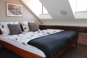 een bed in een kamer met enkele ramen bij Agnes - Apartments in Praag
