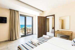 a bedroom with a bed and a view of the ocean at Theo Star Beach Hotel in Malia