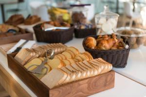 a table with a tray of bread and pastries at Hôtel Miléade L'Orangeraie - Menton in Menton