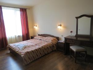 a bedroom with a bed and a dresser and a mirror at Apartments & Studios Mountain Romance in Bansko +77 photos