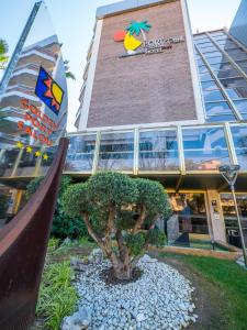 un edificio con un árbol delante de él en Golden Port Salou & Spa en Salou