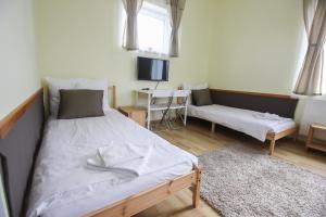 a bedroom with a bed and a couch and a table at Gyevitur Apartman in Algyő