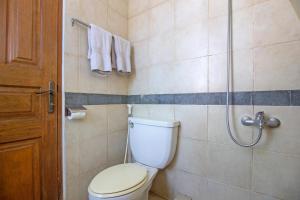 a bathroom with a toilet and a shower at RedDoorz Plus near Parahyangan University in Bandung