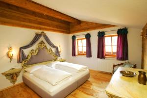 a bedroom with a bed and a table and windows at Das Baderhaus in Zell am See