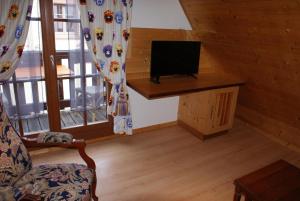 - un salon avec une télévision et une chaise dans une cabine dans l'établissement Studio Ulysse, à Zellenberg