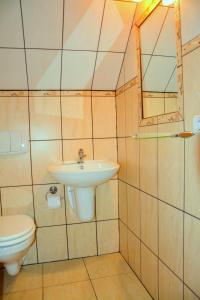 La salle de bains est pourvue d'un lavabo et de toilettes. dans l'établissement Domki DUET, à Dźwirzyno