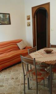 カステッランマーレ・デル・ゴルフォにあるAppartamento Castellammareのベッド、テーブル、テーブル、椅子が備わる客室です。