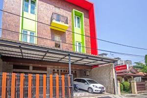 un edificio con un coche aparcado delante de él en RedDoorz near Trans Studio Mall 2 en Bandung