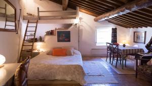 Schlafzimmer mit einem Bett, einem Schreibtisch und einer Leiter in der Unterkunft La Cordière in Lourmarin