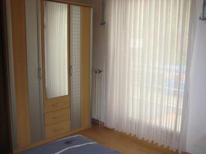 een slaapkamer met een spiegel, een dressoir en een raam bij Am Hafen IS in Büsum