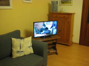 een woonkamer met een tv en een bank bij Am Hafen IS in Büsum