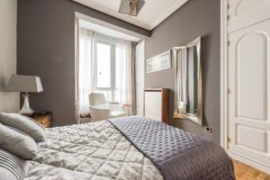 マドリードにあるApartamento en Chamberiのベッドルーム1室(ベッド1台、椅子、窓付)