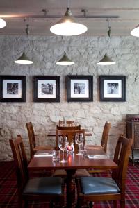 een eetkamer met een houten tafel en stoelen bij The Three Crowns in Chagford