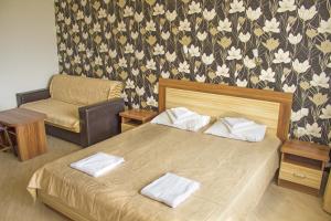 a bedroom with a bed and a chair in a room at Complex Chayka Guest House in Byala