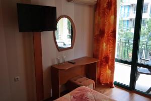 1 dormitorio con mesa, espejo y cama en Tanya Hotel en Sunny Beach