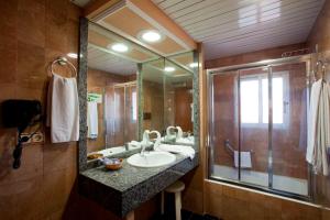 a bathroom with a sink and a large mirror at Hotel Cabana in Benidorm