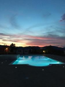 a large swimming pool with a sunset in the background at Agriturismo Quartuccio in Oricola